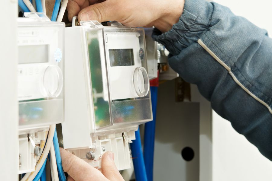 Electrician installing smart meter in electricity box