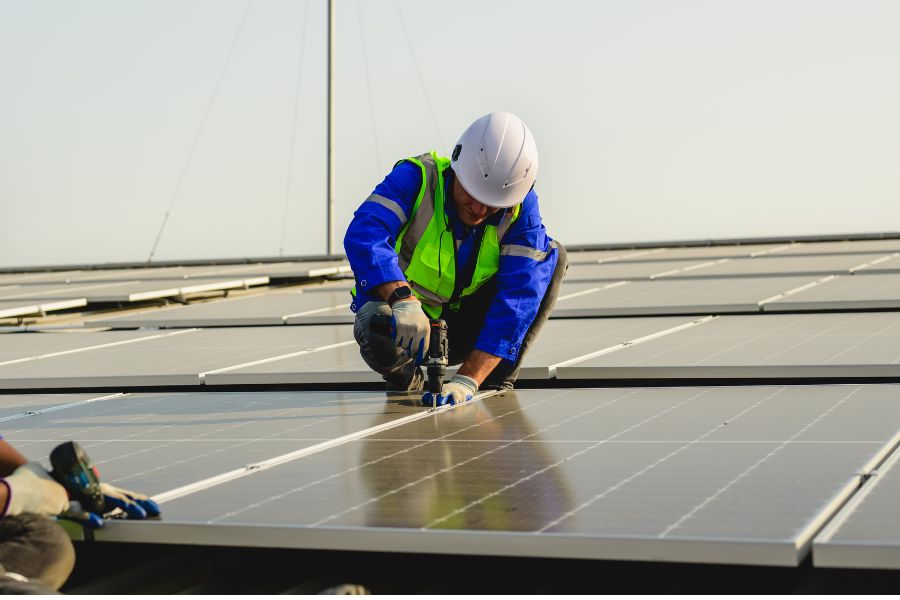 Technicians installing solar panels on building roof