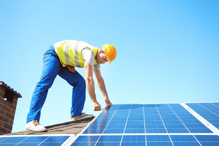 Solar panel technician installing PV panels outdoors