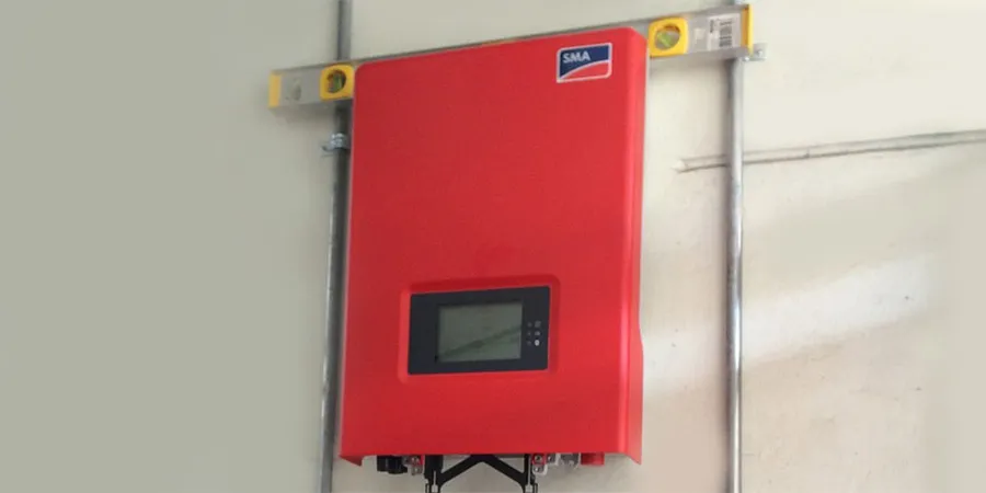 red sma inverter mounted on the greyish white wall with metal tube piping